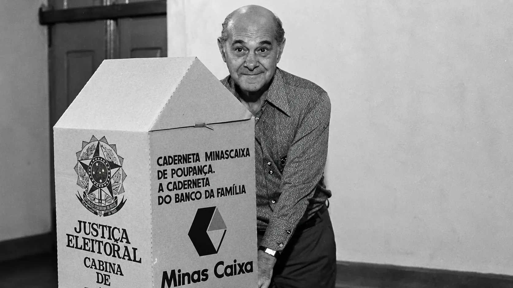 As cabines de votação já tiveram publicidade de marcas nos anos 80 4 Homem idoso diante da cabine Minas Caixa 7