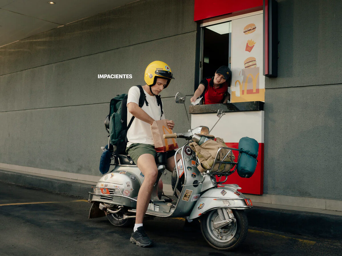 Campanha do McDonald's mostra clientes impacientes 1 Mochileiro em scooter no drive-thru do McDonald's na campanha Impacientes