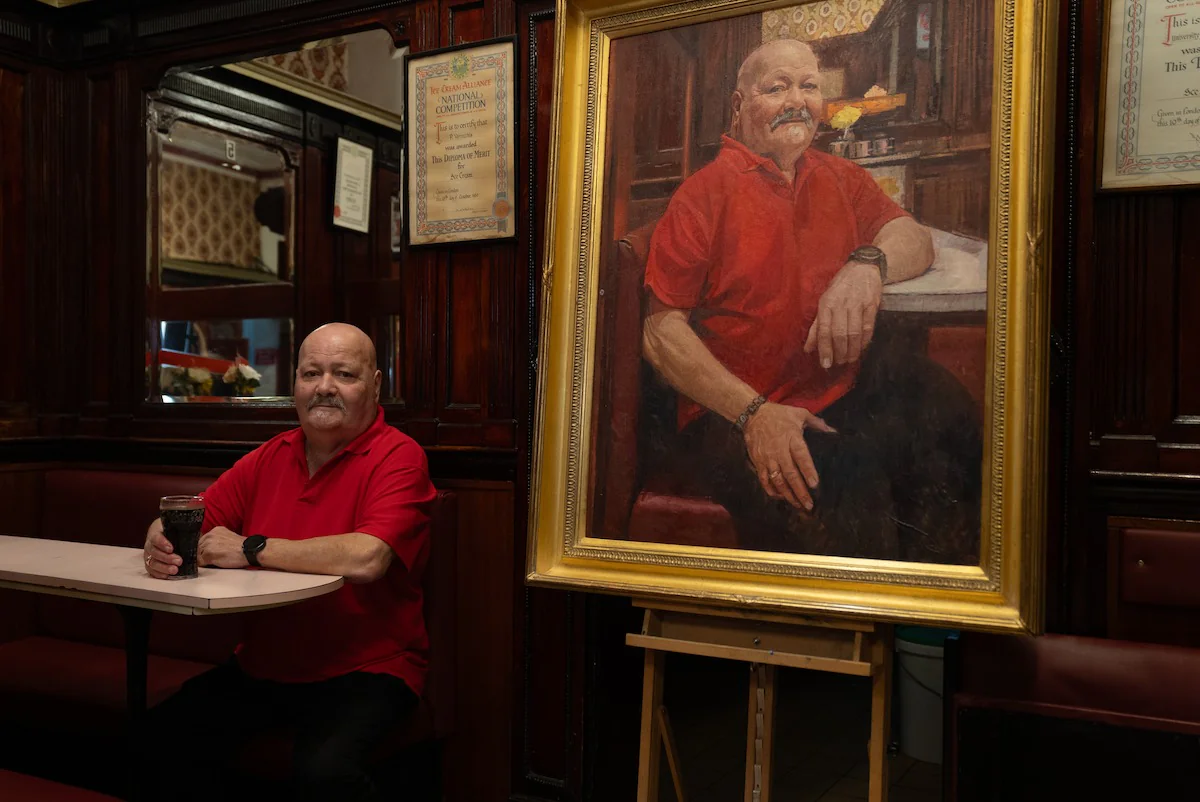 Gino Verecchia com seu retrato no University Café, em Glasgow